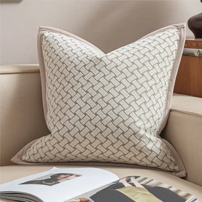 housse de coussin de luxe couleur lin sec présentant un motif en jacquard géométrique tissé avec subtilité, et une bordure de tissu assortie
