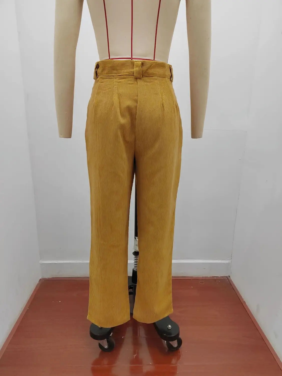 Pantalon en velours côtelé jaune moutarde taille haute ample avec détails de passants de ceinture, présenté de face.