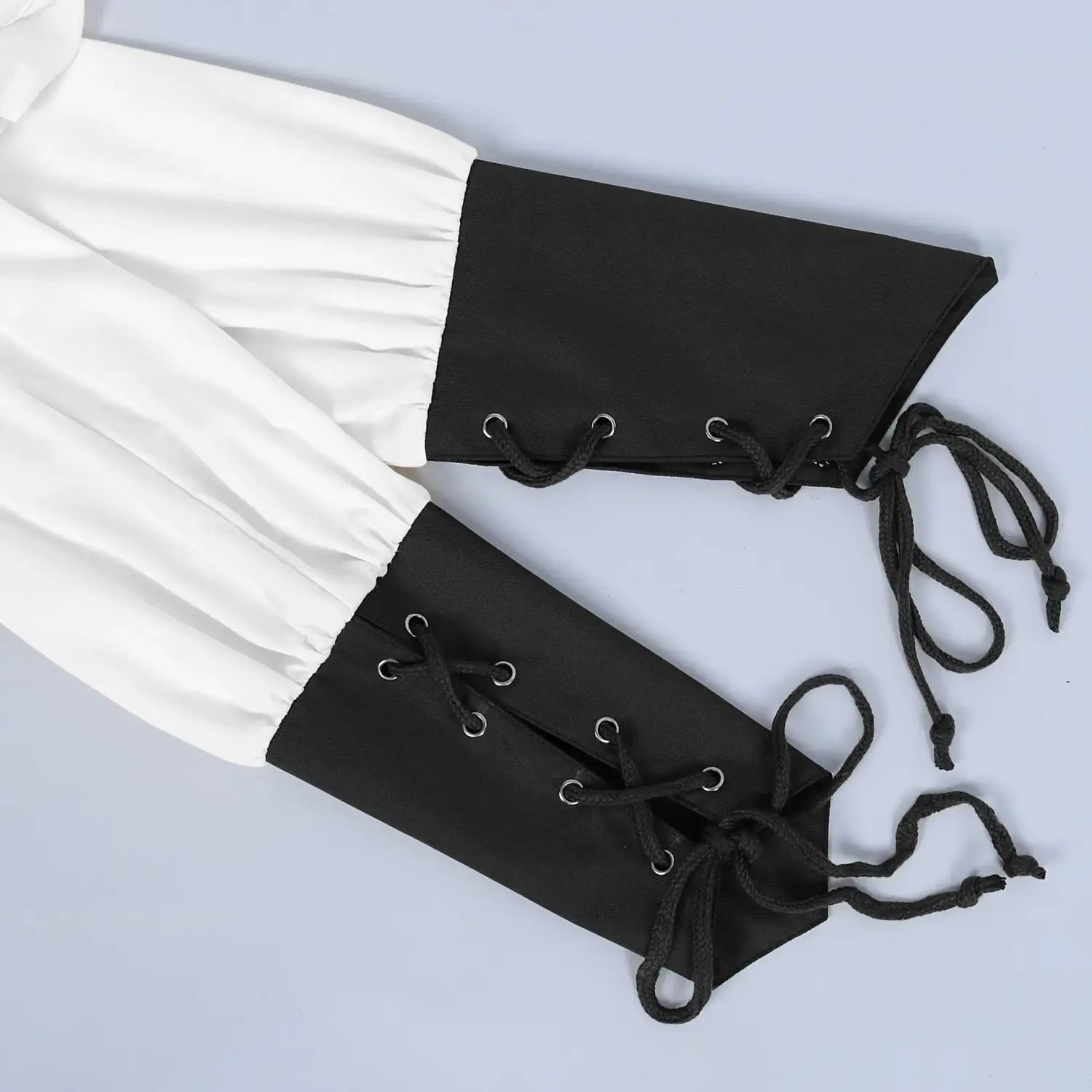 Black lace-up arm cuffs paired with white fabric sleeves displayed from the front on a mens pirate medieval renaissance lace up shirt.