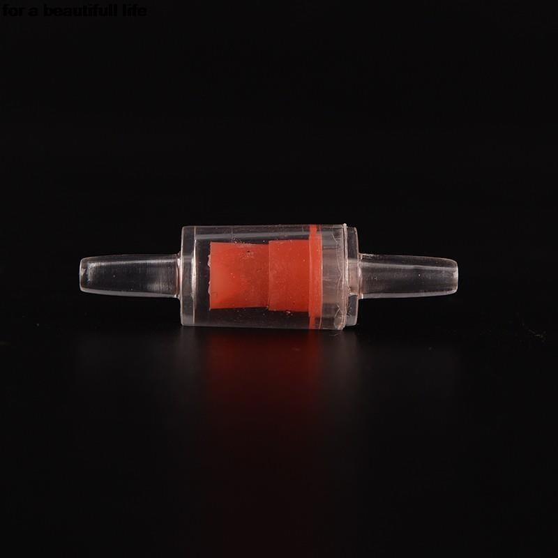 Válvula de retención de plástico transparente para bomba de aire de acuario con un componente interno naranja brillante para un flujo de aire unidireccional.