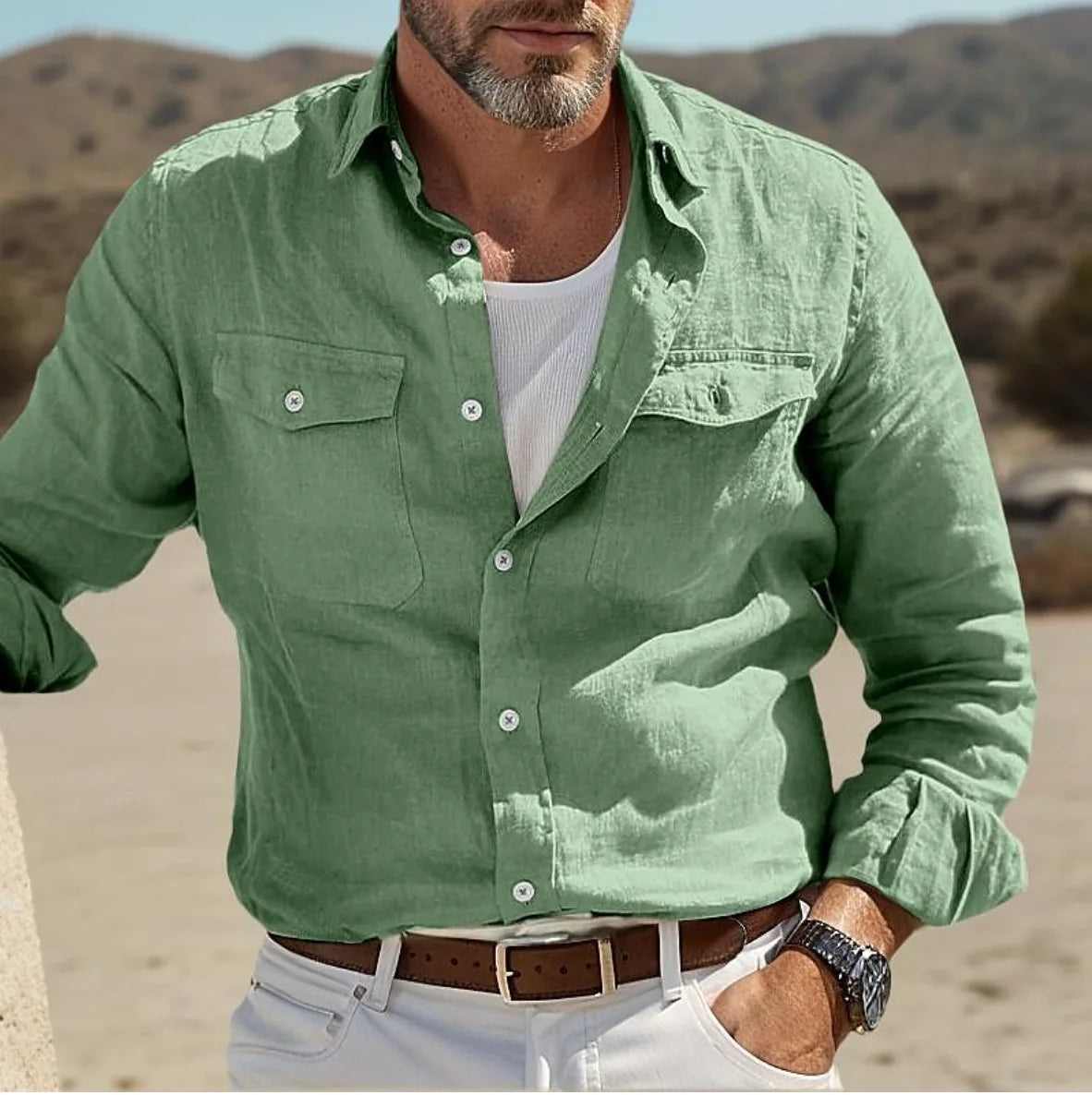 A man wearing a light green men casual linen button up shirt with long sleeves chest pockets and white buttons.