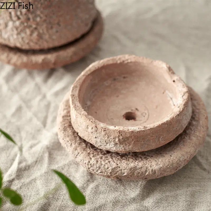 Rustikaler Terrakotta-Keramik-Blumentopf mit strukturierter, erdiger Oberfläche und passendem Deckel, konzipiert als handgefertigte Keramik-Blumenuntertasse und als Untersetzer für eine grüne Pflanze.
