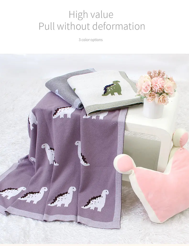 Lila Dinosaurier-gestrickte Babyddecke aus Baumwolle mit weißen und grünen bestickten Dinosauriern, für die Nutzung im Gitterbett.
