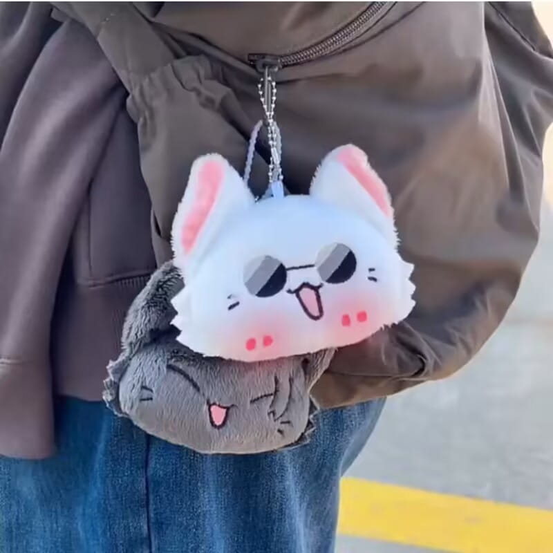 White and gray plush cat keychain with pink inner ears black sunglasses rosy cheeks and tongue sticking out from the Gojo and Geto Cat Plush Anime Keychain collection.