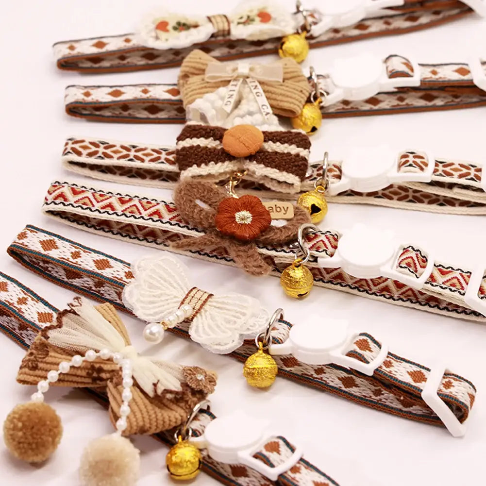 Adjustable floral cat collar with embroidered patterns woven fabric bows and golden bells featuring adjustable length for comfortable fit.