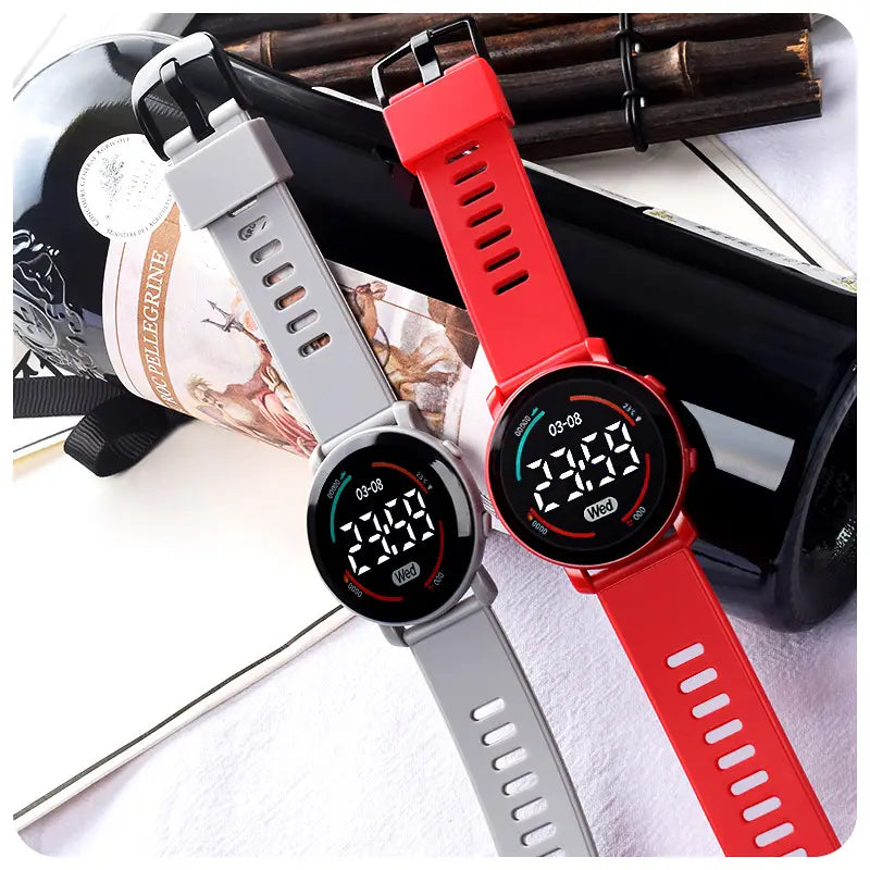 girls digital sports watch waterproof led wristwatch featuring red and gray digital displays with silicone straps showing time date and fitness metrics on their screens.