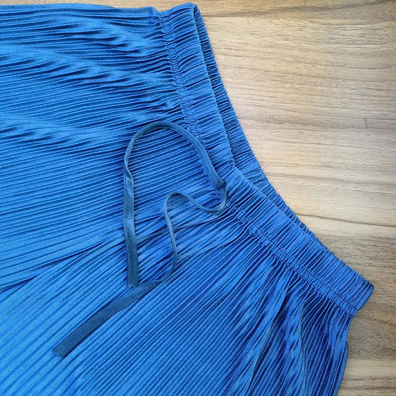 eine lebhaft blaue, weit geschnittene, plissierte Sommerhose für Damen mit einem elastischen Bund und passendem Bindeband