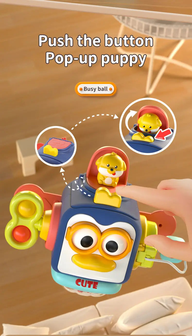Jouet à ressort pop-up bleu et jaune en forme de chiot, avec un corps de type robot et des boutons colorés, proposé dans le jouet de voyage cube d’occupation Montessori pour un jeu favorisant le développement.