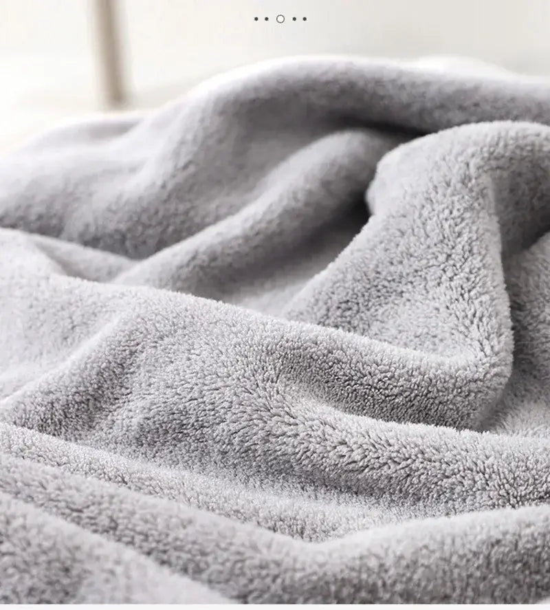 Serviette de bain pour bébé à capuche en peluche grise douce, avec une surface texturée confortable, réalisée dans un matériau absorbant.