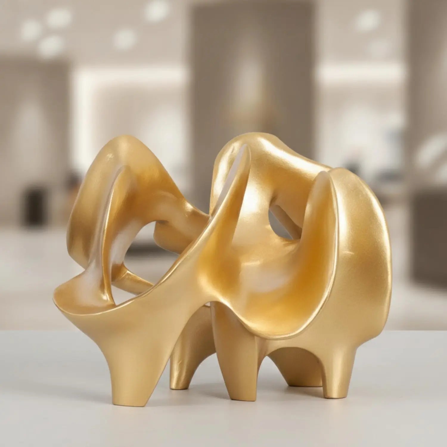 golden glossy resin decorative item featuring an abstract geometric sculpture of high-heeled shoes with flowing intertwined forms and sculpted heels