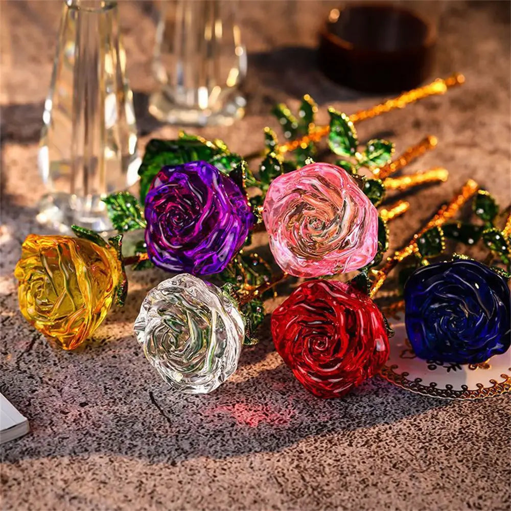 Vibrant translucent crystal glass roses in purple pink yellow clear red and blue with green leaf accents displayed as a gift for Valentine’s Day.
