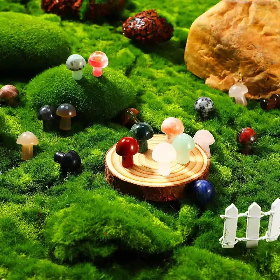 Una colección de coloridas figuras de hongos de resina translúcida pulida en varios tamaños dispuestas sobre un corte circular de madera para la decoración natural de mini jardines con cristales.