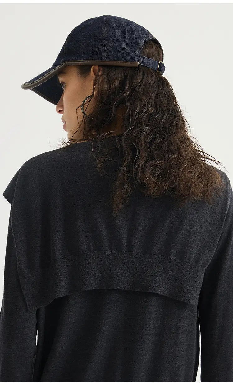 Dunkelblauer Denim-Basecap mit braunem Lederbesatz und verstellbarem Riemen, dargestellt mit dem Wollstrick-Schulterwickel-Cape-Schal.
