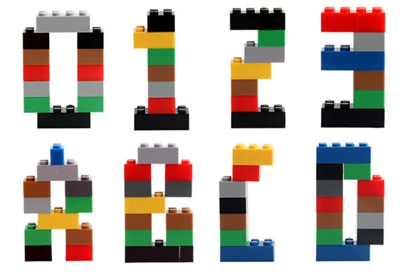 Colorful plastic creative building blocks in a diy creative building set for kids spell out numbers 0 through 3 and letters a through d.