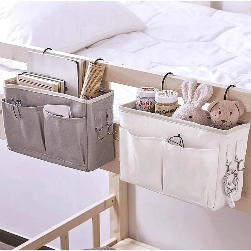 Zwei Aufbewahrungs-Organizer für das Bett aus Leinen, die am Bettgestell befestigt werden, in Grau und Weiß, mit mehreren Taschen und Metallhaken.