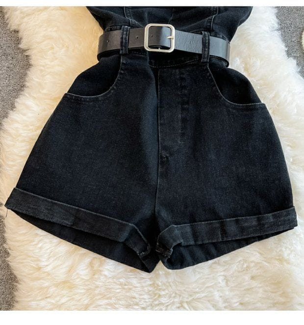 black high-waisted denim shorts with rolled cuffs and a matching black belt with a silver buckle as part of a denim jumpsuit off shoulder summer romper