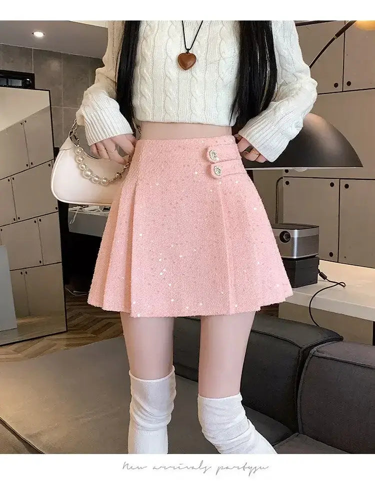 Rosa Bouclé-Falten-Minirock mit rosafarbenem paillettenartigem, strukturiertem Stoff und zwei dekorativen Knöpfen am Bund.