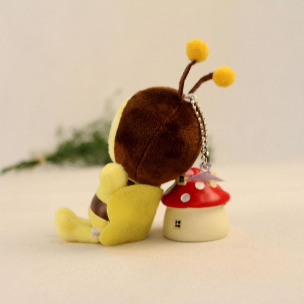 Yellow plush bee stuffed animal with brown head and antennae featuring a soft red and white mushroom house accessory
