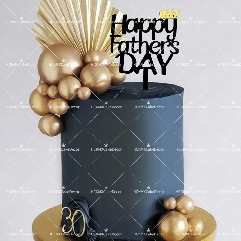 A sleek navy blue cake decorated with gold metallic balloons and fan-like embellishments topped with a black acrylic Father’s Day cake topper featuring a golden crown.