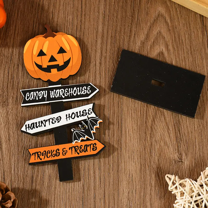Orange wooden pumpkin-shaped Halloween directional sign with black text on white and orange arrows for desktop decoration.