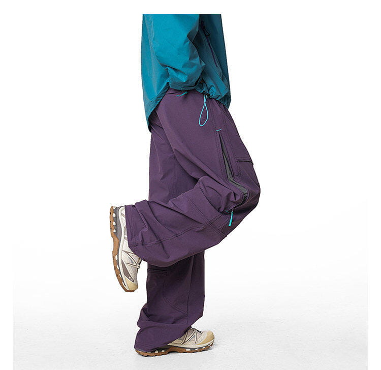 pantalones cargo impermeables de senderismo para hombre en color morado, con tiradores de cremallera verde azulado y múltiples bolsillos, elaborados con un tejido resistente de secado rápido.