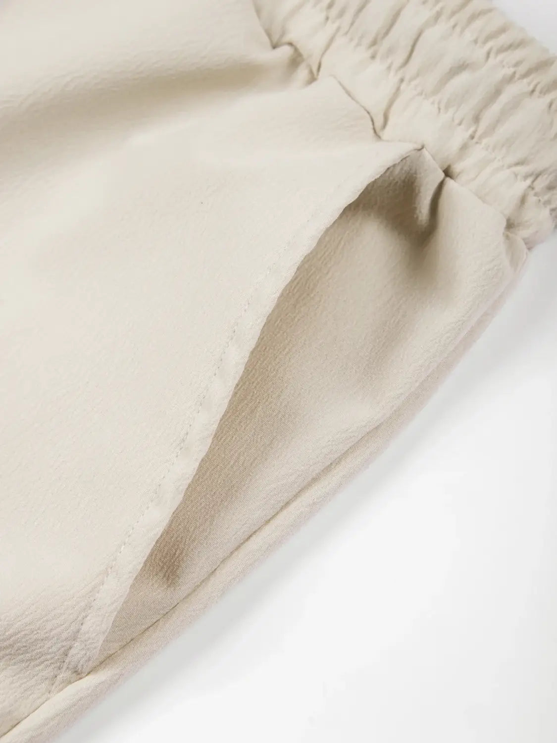 Beige Leinenhose mit elastischem Bund, weichem, glattem Stoff und sauber genähten Nähten aus dem Herren-Leinen-Zweiteiler für den Sommer.