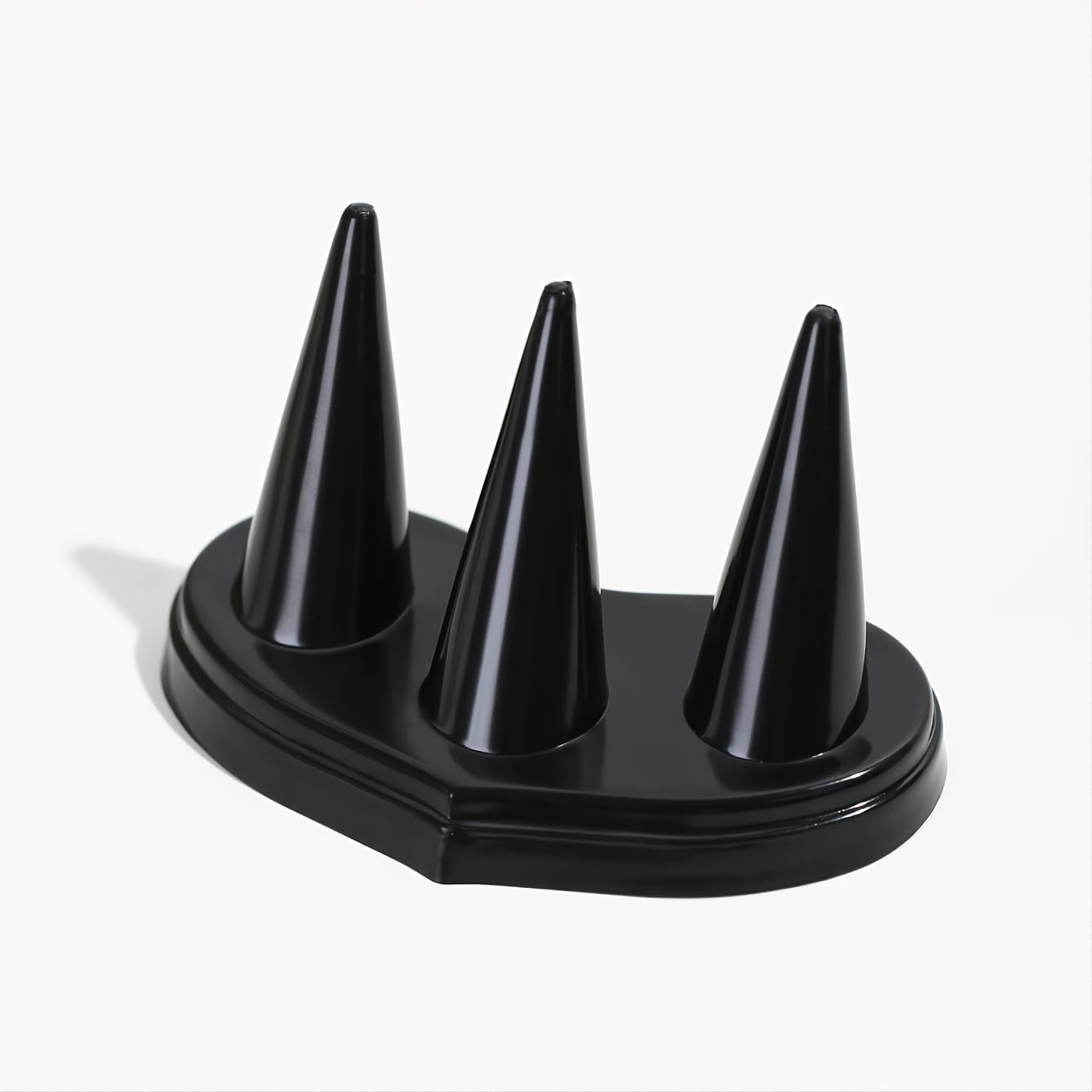 Support de bague en plastique noir brillant avec trois pointes coniques pour l’exposition des bagues.