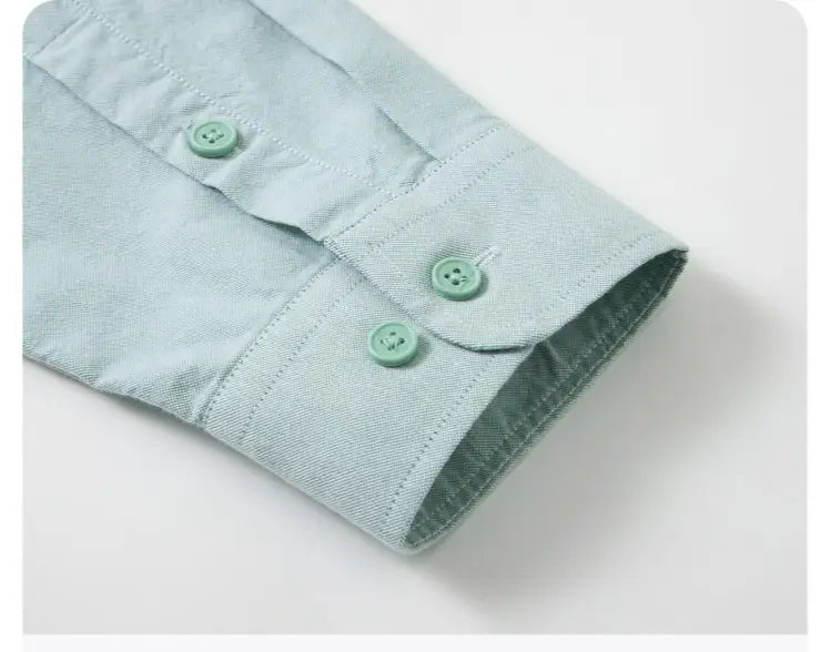 Camisa Oxford de algodón color azul claro, corte slim fit, para hombre, con puño de camisa de mezclilla azul claro y botones verde menta a juego.