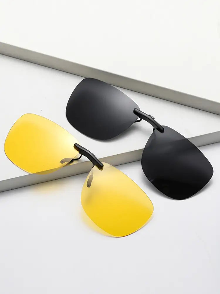 a pair of polarized clip on night vision sunglasses with one yellow lens and one black lens featuring sleek metallic frames