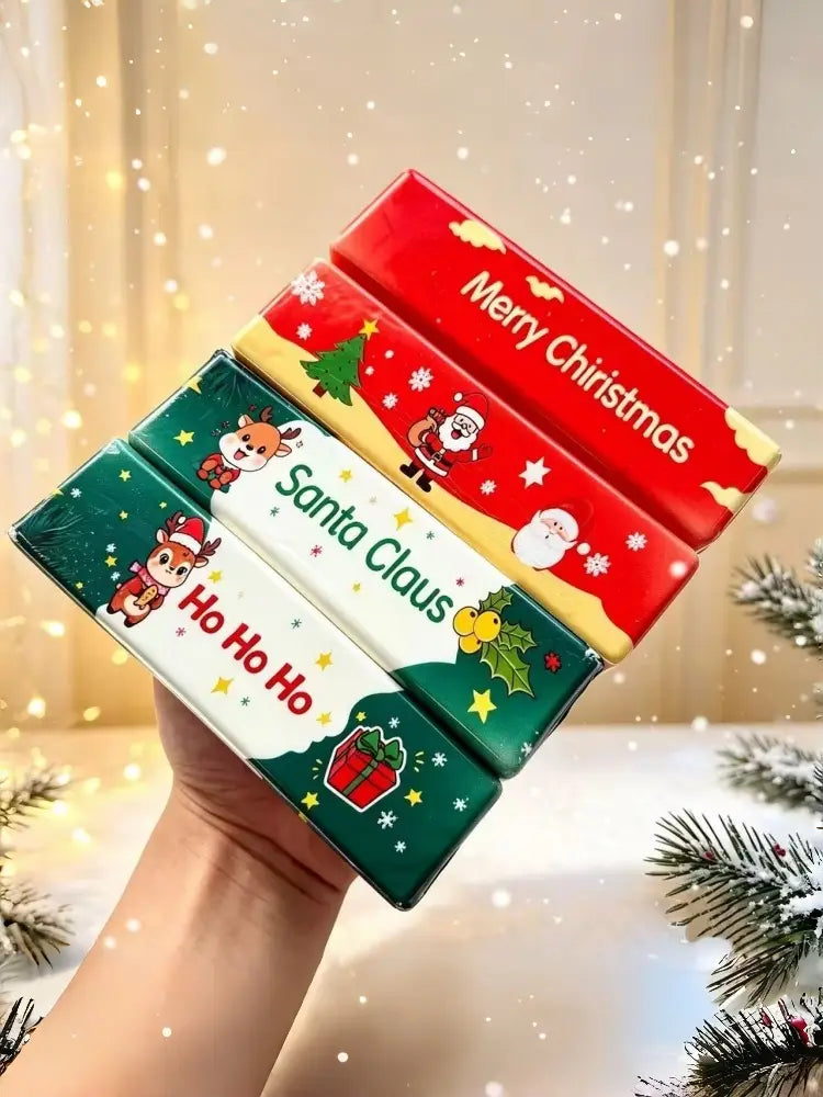 Juguetes antiestrés blandibles de alivio lento con tema de Santa Claus de Navidad envueltos en papel de seda festivo de color rojo, verde y amarillo, con diseños de Santa Claus y renos.