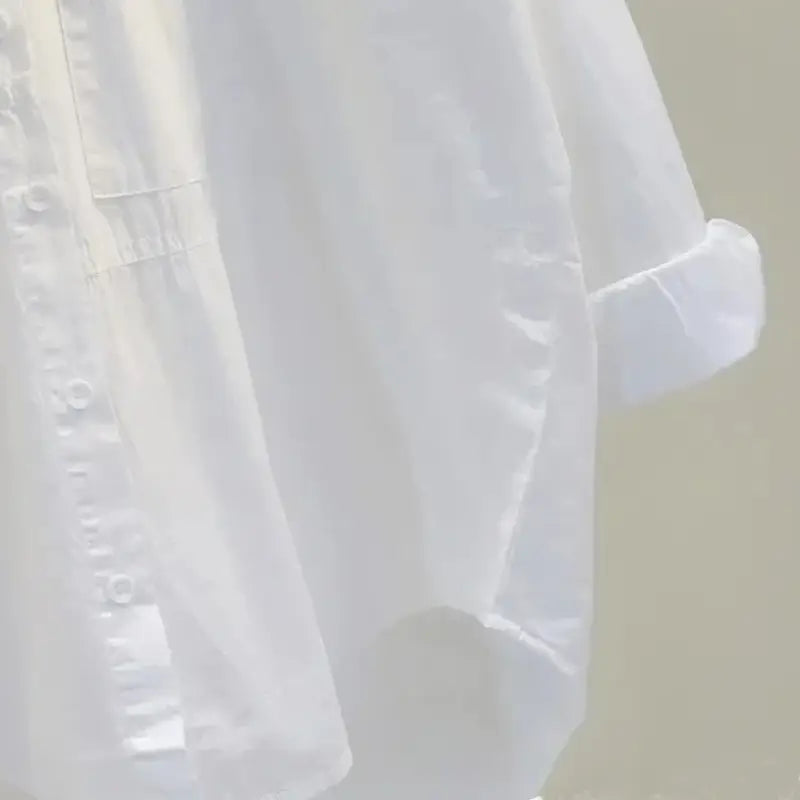 a delicate white sheer blouse for women with a button-down front and rolled-up sleeves suitable as a white button down office blouse featuring lightweight fabric measured in inch and cm.