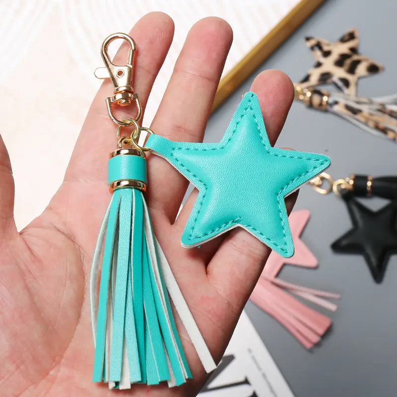 Turquoise star-shaped leather keychain with a matching tassel featuring alternating turquoise and white fringes for women.