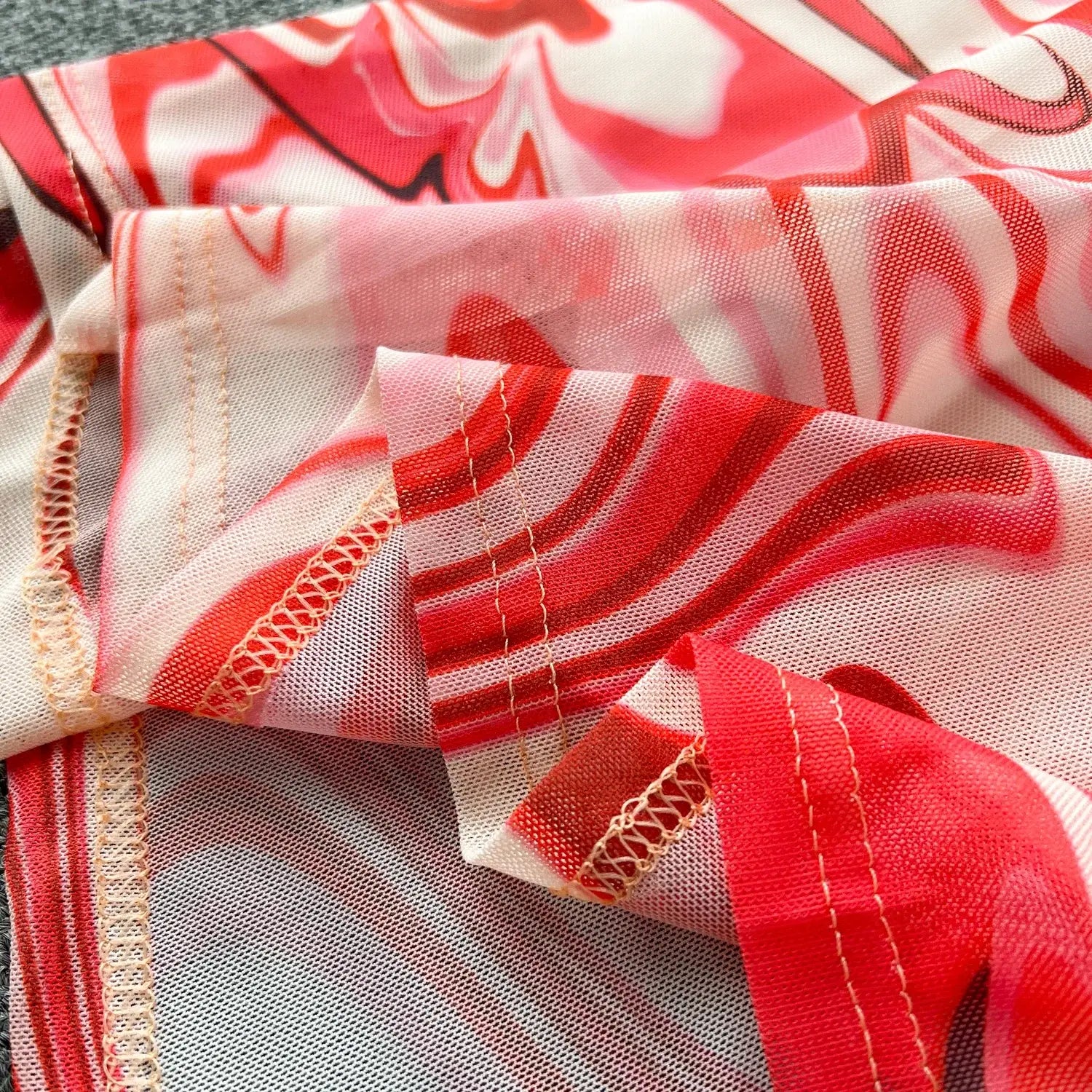 a two piece mesh skirt set in vibrant red and white marble print with delicate lace trim and an elastic closure type