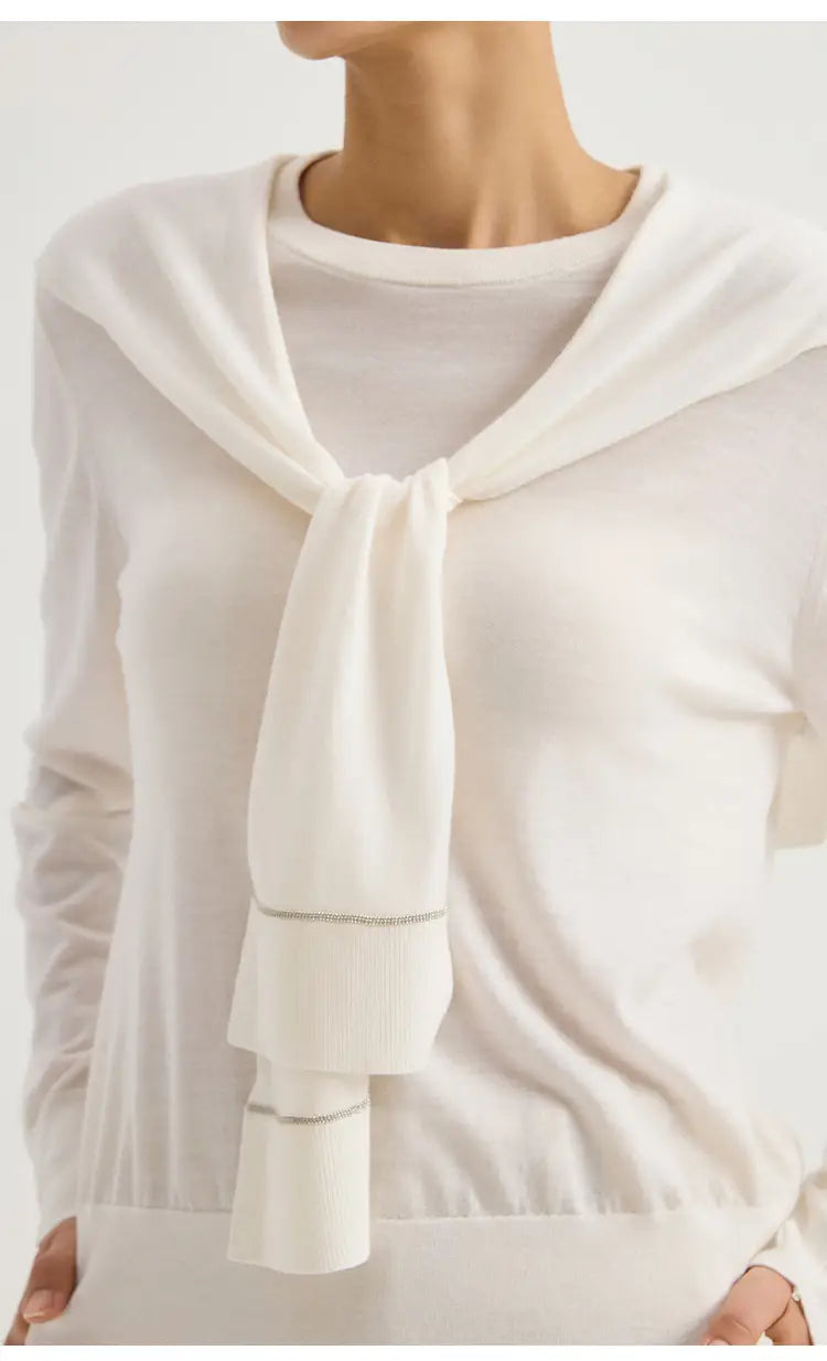 Ein weicher weißer Wollstrick-Schulterwickel-Cape-Schal mit drapiert gebundenem Halsausschnitt und dezentem geripptem Detail.