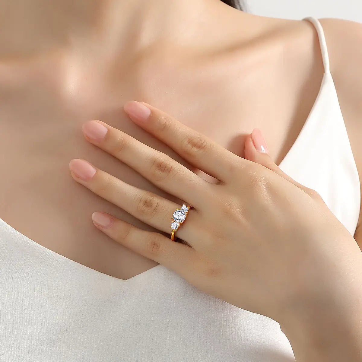 Bague trois pierres en or 18 carats en moissanite avec une monture délicate en or comportant trois pierres claires étincelantes dans un design de trio classique.
