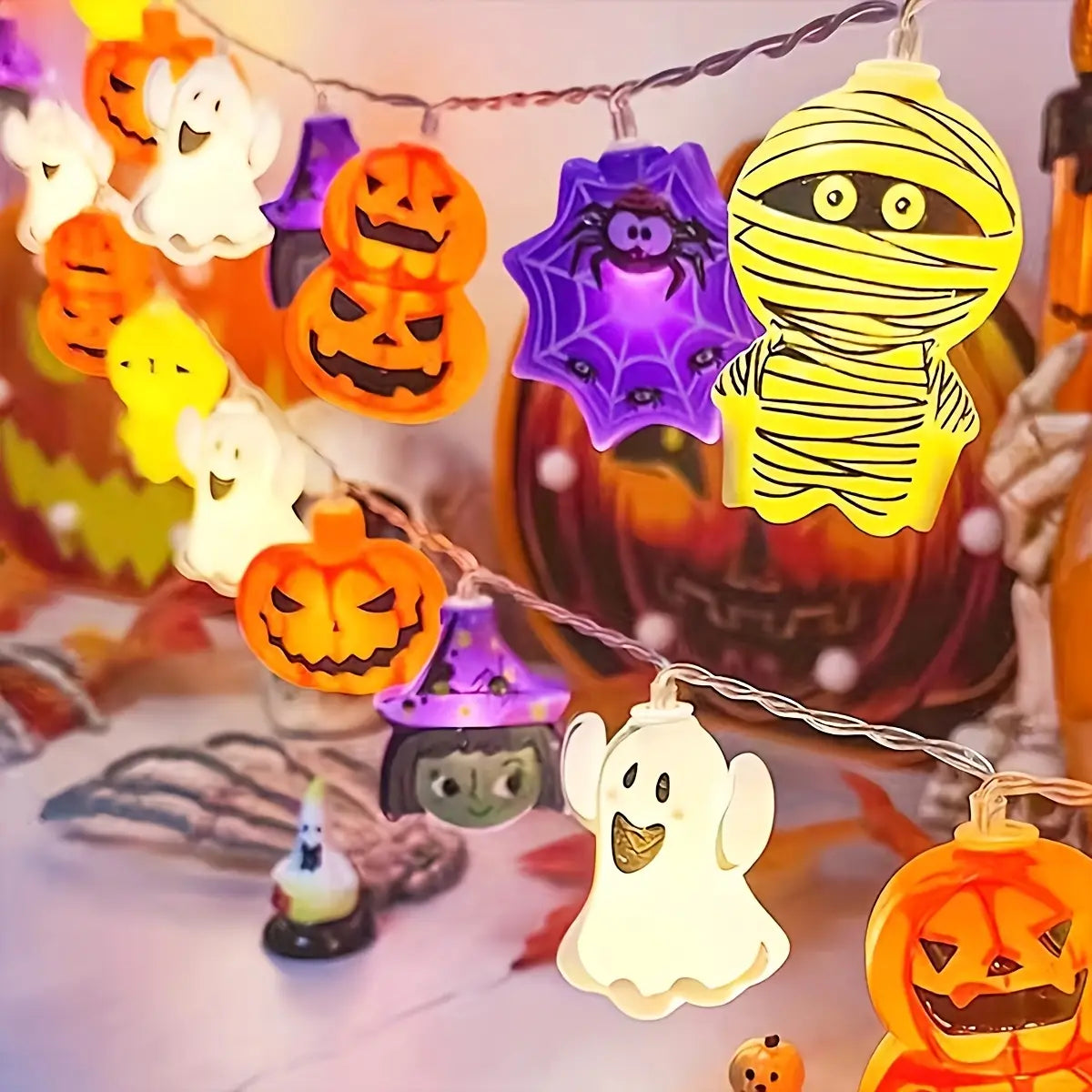 A string of halloween led string lights featuring colorful illuminated plastic figures including orange pumpkins white ghosts purple spiders and yellow mummies for halloween decor.