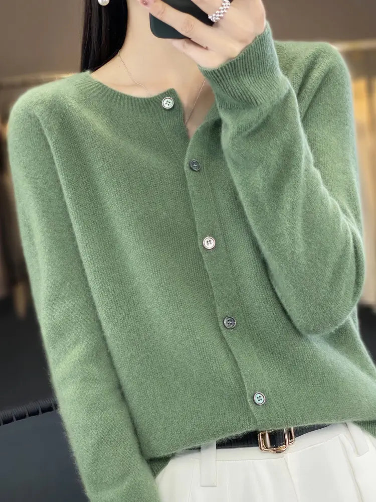 A soft moss-green merino wool cardigan for women featuring a round neckline and silver-toned buttons.
