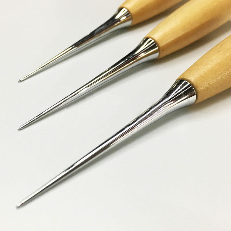 Set of three leather sewing awl tools with wooden handles and polished silver metal embroidery needle tips.