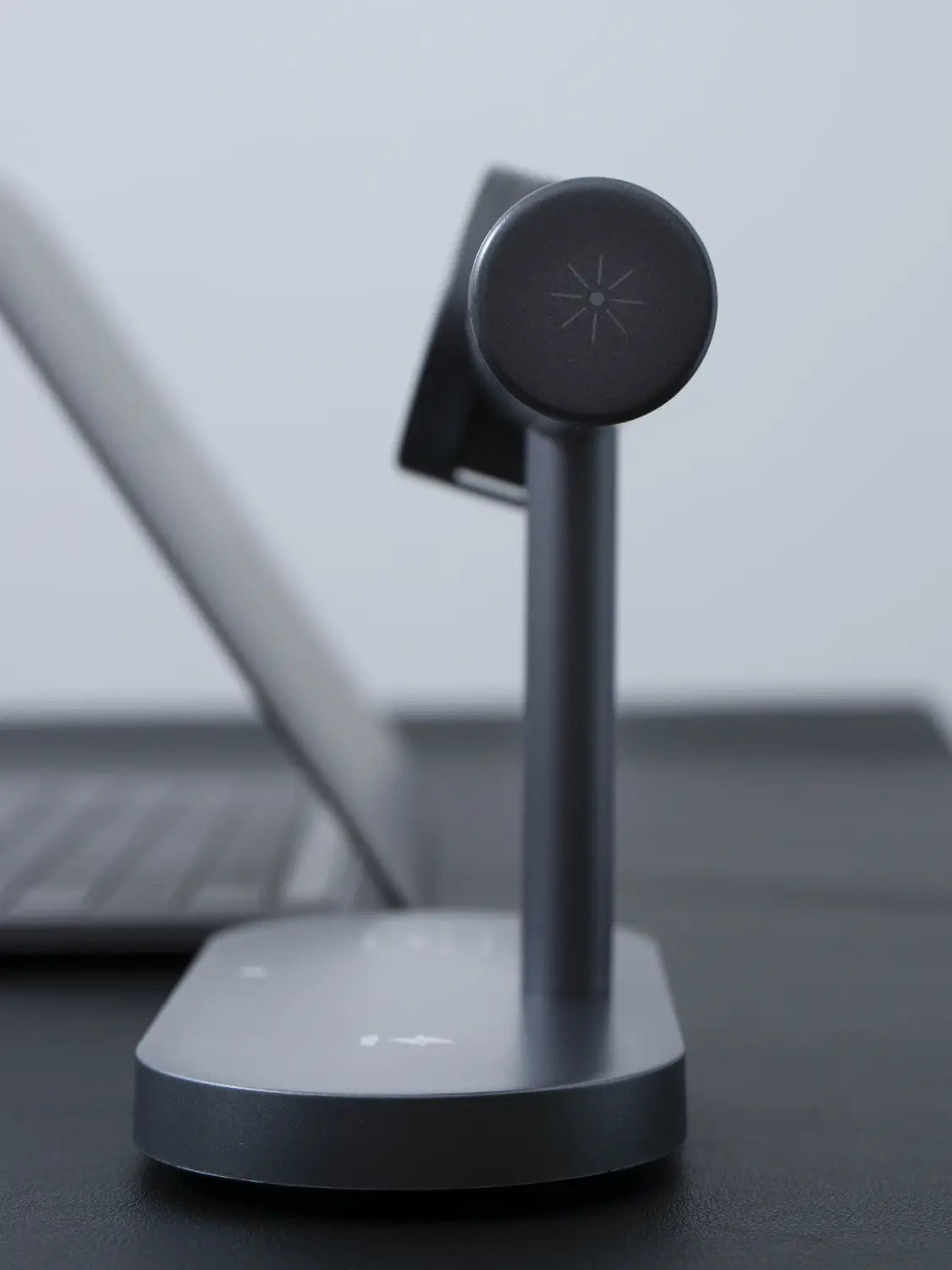Station de charge sans fil élégante noire mate 25 W 7-en-1 à charge rapide, avec un dessus circulaire minimaliste comportant un logo d’étoile en relief.