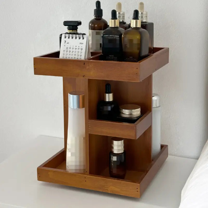 Un organisateur de maquillage en bois à trois étages pivotant aux tonalités chaudes, au design minimaliste, contenant divers flacons de soins de la peau et un petit calendrier.