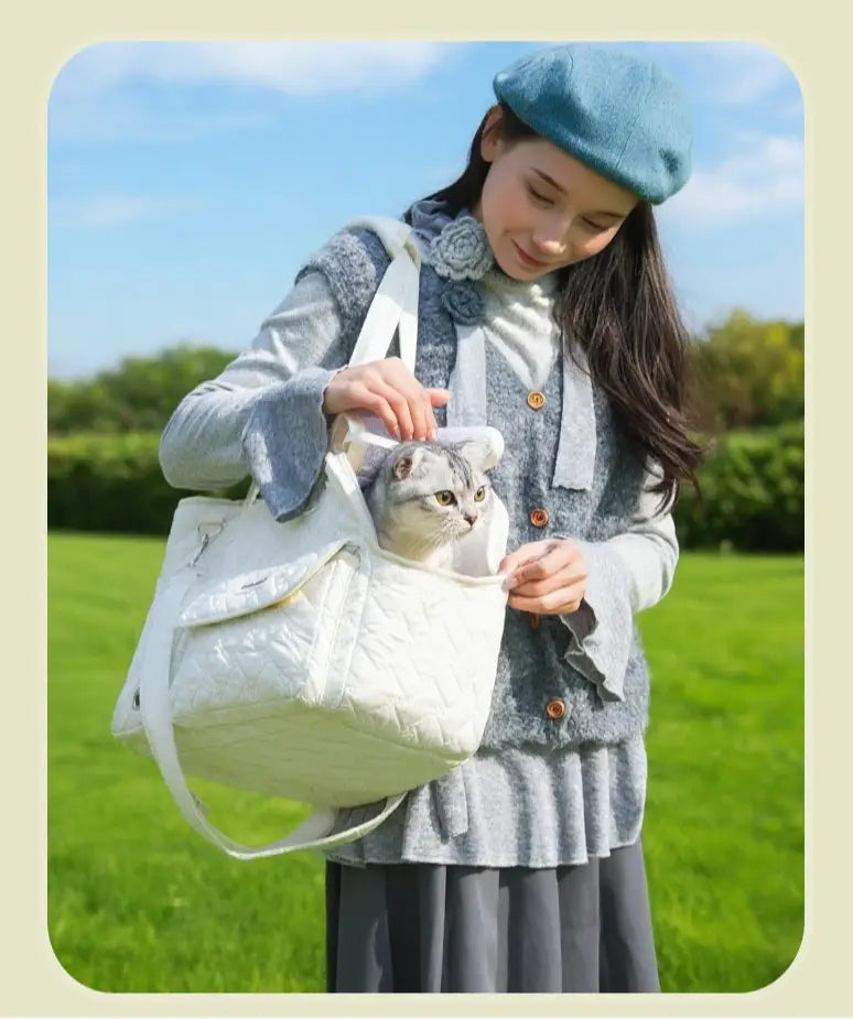 Bolsa transportín acolchada blanca para mascotas con asas blandas y un interior acogedor, diseñada para transportar gatos y perros pequeños.