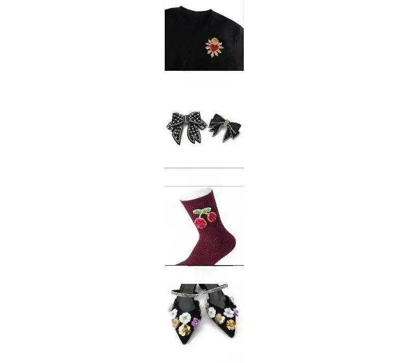 Pull noir avec une broche en forme d’aile d’ange cœur en perles rouges et dorées, cousue sur l’avant, sous forme de pièce d’ornement pour sac.