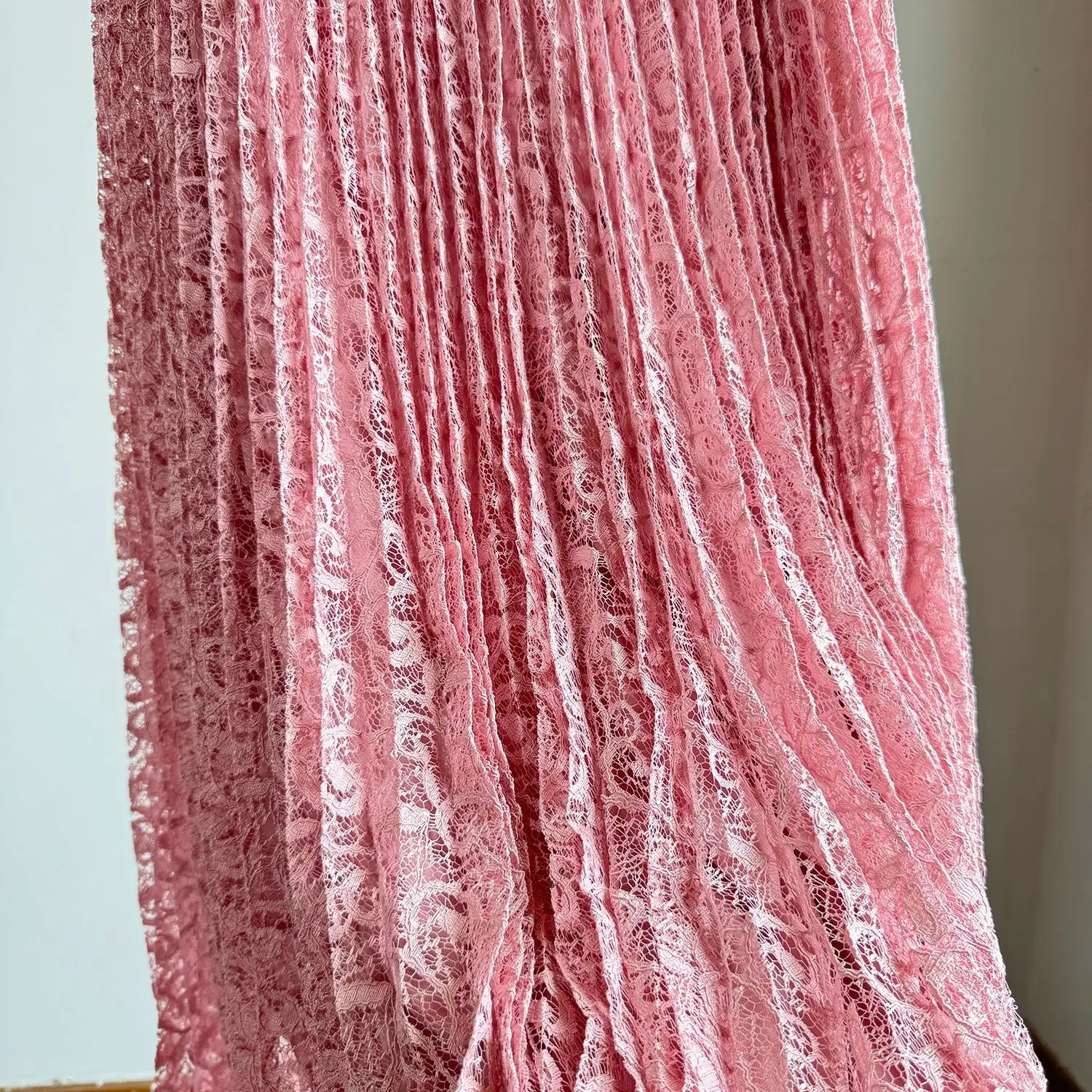 A delicate pink lace high waist pleated midi skirt with intricate floral patterns designed for Y2k streetwear.
