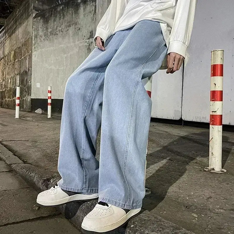 Jeans à jambes larges en denim à lavage clair pour hommes, avec un style streetwear coréen ample et une silhouette décontractée à jambe droite.