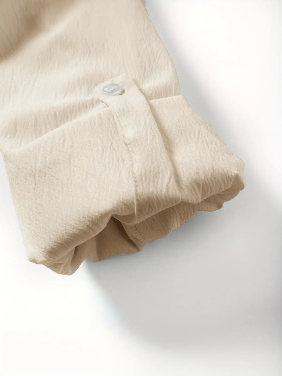 Beige Baumwoll-Ärmel mit dezent strukturierter Webung und einer Manschette mit einfachem Knopf-Detail aus dem Herren-Leinen-Zweiteiler für den Sommer.