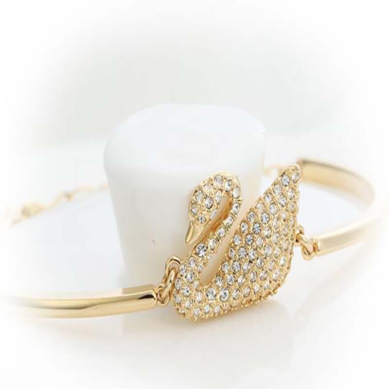 Bracelet jonc à tonalité dorée en forme de cygne, orné de cristaux transparents, présenté dans le bracelet jonc à breloque de cristal de cygne.