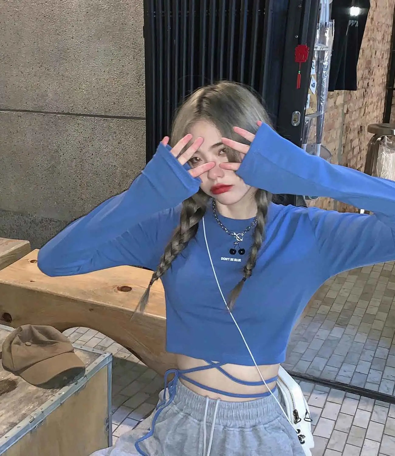 Damen-Langarm-Crisscross-Crop-Top in Blau mit Frontreißverschluss und „dont be blue“-Text auf der Brust.