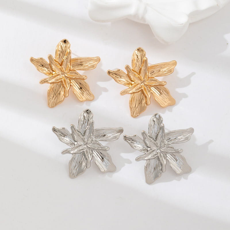 gold and silver flower-shaped stud earrings with textured layered petals complementing an adjustable double layer flower ring.