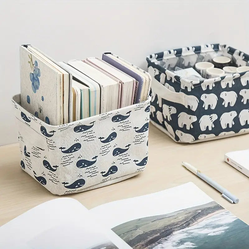 Panier de rangement pliable en toile blanche avec des motifs de baleine et d’ondes bleu marine, conçu comme une boîte de rangement polyvalente.
