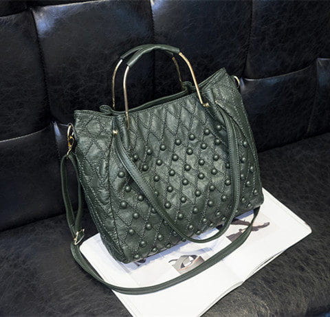 Bolso de hombro de cuero verde oscuro acolchado con tachuelas metálicas y un diseño estructurado que muestra el compartimento interior.